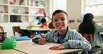Smile, writing and face of child in classroom at elementary school for learning, growth or development. Happy, education and portrait of boy kid student with assessment, test or project at academy.