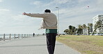 Back, man and dance with headphones at beach for travel, vacation fun and listening to music. Male person, jumping and movement with rhythm, audio and streaming podcast for holiday freedom at seaside
