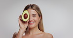 Skincare, avocado and face of woman in studio with beauty, natural and moisturizing benefits for health. Portrait, wellness and person with fruit for facial glow with dermatology by white background.