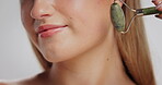 Skincare, face roller and woman in studio for facial massage, treatment and blood circulation. Gua sha, beauty routine and female person with cosmetic tool for clear skin, wellness and dermatology.