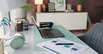 Documents, headset and laptop on desk in home office for planning, remote work or research. Computer, paperwork and pen at workstation in empty apartment for freelance or small business startup
