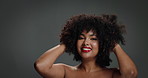 Face, hair care and woman in studio, curls and confidence with texture on grey background. Portrait, cosmetics and happy person with volume, shine and beauty with glow, wellness and treatment