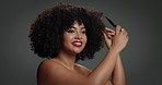 Smile, woman and brush for hair care in studio for detangling, natural growth and afro volume. Happy, African female person and comb for textures, maintenance and scalp treatment on gray background
