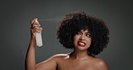 Woman, afro and hair care with spray in studio, smile and test product for beauty on background. African girl, bottle and happy with liquid for benefits, growth or collagen for texture with cosmetics