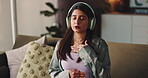 Yoga, headphones and woman with breathing on sofa for guided meditation, mindfulness or calm audio. Yogi, girl and relax with zen playlist in home for anapanasati, stress relief or spiritual wellness
