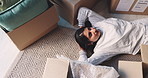 Happy woman, relax and thinking with boxes in new home above for relocation or fresh start. Top view, female person or homeowner lying on floor with smile or move for dream house, comfort or property