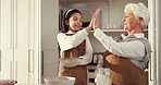 Baking, high five and kid with grandmother in kitchen for teaching, fun or bonding together. Happy, celebration and girl child with senior woman for learning to prepare dessert on weekend in home.