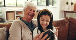 Grandma, phone and laughing with child, home and watching videos on social media, online or website. Happiness, granddaughter and bonding with old woman in house, funny film and entertainment on app