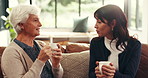 Coffee, conversation and woman with senior mother on sofa in home for advice, bonding or connection. Happy, tea and female person with elderly mom for talking, catch up or discussion in living room.