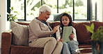 Grandma, grandchild and entertainment with tablet on sofa for online streaming together in home. Grandmother, granddaughter or kid with technology on couch for app subscription or network in house