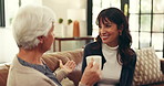 Senior mom, woman and coffee on sofa, chat and happy with visit, reunion and story with bonding in home. Elderly person, mother and daughter with drink, tea or relax with conversation at family house
