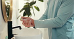 Home, washing hands and man in bathroom, cleaning and remove bacteria with disinfection. Apartment, closeup and person with faucet, water and hygiene with skincare, tap and liquid with safety or soap
