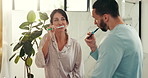 Brushing teeth, dental hygiene and couple in bathroom, wellness and cleaning mouth. Home, morning routine and man with woman, oral health and remove plaque with fresh breath, grooming and benefits