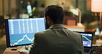 Businessman, back or night with stock market for analysis, statistics or virtual investment. Man, broker or employee working late with computer screen, graph or chart for online trading in workplace