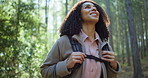 Happy woman, hiking and explore with bag in forest for natural sightseeing, journey or adventure. Female person, hiker or walking with smile or backpack for trekking or outdoor exploration in nature