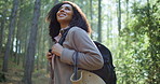 Happy woman, outdoor or hiking with bag in forest for natural sightseeing, journey or adventure. Female person, hiker or smile with backpack, trees or wilderness for trekking or exploration in nature