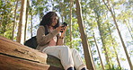 Woman, happy and phone in forest, hiking or check map for landmark, location and low angle in summer. Person, smartphone and mobile app for trekking, adventure and smile for break on log in Brazil