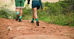 Couple, back and holding hands with shoes for hiking journey or outdoor adventure together. Man, woman or hiker with dirt path for trekking commitment, walk or health and wellness in forest or woods