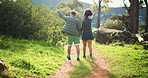 Couple, back and holding hands with hiking trail for sightseeing or outdoor adventure in nature. Man, woman or trekking with path in forest for exercise, commitment or journey together in woods