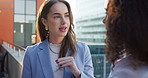 Business women, discussion and talking on balcony in city for proposal, chat or conversation. Female people, employees or colleagues discussing project, company plan or strategy in an urban town