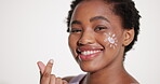 Face, finger heart and skincare with black woman in studio for lotion or moisturizer satisfaction. Beauty, cream and smile of African model isolated on white background for cosmetics or dermatology