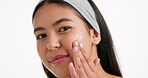 Studio, face and woman with cream for self care, soft or hydration of healthy skin with dermatology. White background, happy and person with moisturizer for skincare, mockup space or facial treatment