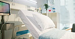 Hospital, healthcare and empty bed for medical recovery, healing and ecg machine with screen. Clinic interior, pillow and room with equipment, heart rate monitor and IV drip for wellness in icu