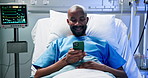 Phone, smile and black man in bed in clinic for typing message, medical update and recovery. Mobile, patient and rest in hospital with app for communication, social media and healing for healthcare