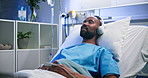Rest, hospital and black man with headphones in bed for surgery recovery, music or healing podcast. Relax, patient and listening to audio playlist in inpatient clinic for medical wellness or radio