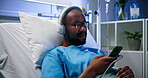 Headphones, hospital and patient with phone in bed for recovery, music and healing podcast. Peaceful, happy black man and mobile app in inpatient clinic for listening to playlist and medical progress