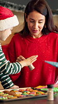 Cookies, sprinkles and Christmas with mother and daughter in kitchen for bonding, holiday season and help. Santa snack, support and festive dessert with woman and kid in family home for baking