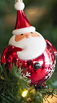 Christmas, tree and Santa bauble for holiday, festive season and party celebration in living room. Ornament, xmas design or decoration for December tradition, bokeh lights and new year event in house