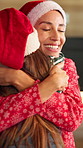 Mom, girl and hug at Christmas in home for love, excited or bonding with santa hat in living room. People, mother and daughter in embrace for merry xmas wish, smile and festive cap at family house