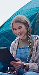 Woman, reading and tablet with tent in nature for research, watching movies and weather forecast. Female person, tech and relax outdoor on camping vacation, browsing internet and online entertainment