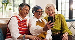 Laugh, old women and friends with selfie in home, show picture and conversation in retirement. Senior people, living room and funny photo for social media post, happy memory and pointing together