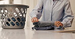 Hands, woman and folding laundry at house for hygiene, clean clothes and housekeeping routine. Female person, basket and fresh apparel of household chores, organizing material and maintenance service