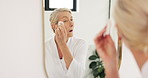 Mirror, skincare and mature woman with cotton swab for face, cleaning or cosmetic application in home. Beauty, reflection and person with facial pad for wellness, toner or hyaluronic acid in bathroom