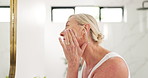 Skincare, face cream and mature woman in bathroom for health, hygiene or wellness treatment in home. Cosmetic, beauty and female person with moisturizer by mirror for facial dermatology in apartment.