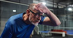 Sport, senior man and tired of tennis on court with sweating, intense workout or match recovery. Retirement fitness, elderly person and exhausted at indoor padel club with training fatigue or burnout