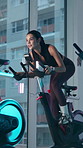 Workout, spin class and woman on bike in gym for fitness, cardio exercise and cycling for wellness. Sports center, health and person on stationary machine for muscle strength, endurance and training