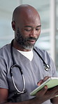 Internet, doctor and black man in clinic, tablet and typing with healthcare, email and research. Mature person, medical service and professional in hospital, review diagnosis or app with connection