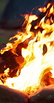 Camping, night and warm with fire outdoor for adventure, discovery or exploration of wilderness. Dark, flames and heat with wood burning on ground at campsite for holiday, travel or vacation