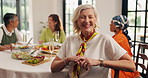 Face, friends and old woman with food, smile and social gathering with happiness. Mature people, home and reunion in living room, bonding together and talking with weekend break, relax and retirement