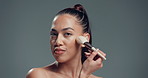 Beauty, woman and makeup brush on face in studio for blush application, powder and aesthetic. Mockup space, girl and self care on gray background with skin contour, blend cosmetics or glamour routine