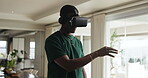 African, man and headphones in home with VR headset, hand gestures and navigation for virtual reality. Technology, person and digital in house with movement, gaming and equipment for 3D experience. 