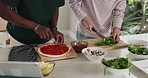 Cooking, hands and friends with pizza in kitchen for meal, dinner or food for health. Ingredients, vegetables and male people with preparing supper or lunch on board for wellness diet in apartment.