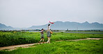 Plane, running and toy with family on farm from back for bonding, excitement or playful fun. Agriculture, flying or shoulders with mother, father and daughter outdoor in countryside for freedom