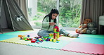 Child, relax and playing with blocks at house for learning, fine motor skills and problem solving. Kid, girl and tower with educational toys for education, cognitive development and building games