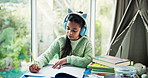 Headphones, homework and girl with books for writing, thinking of answer and learning with music. Education, home and child with audio, lesson podcast and sound to concentrate on academic activity