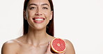 Cosmetic, grapefruit and face of woman in studio with natural, beauty and facial treatment for hydration. Skincare, glow and portrait of person with citrus fruit for dermatology by white background
